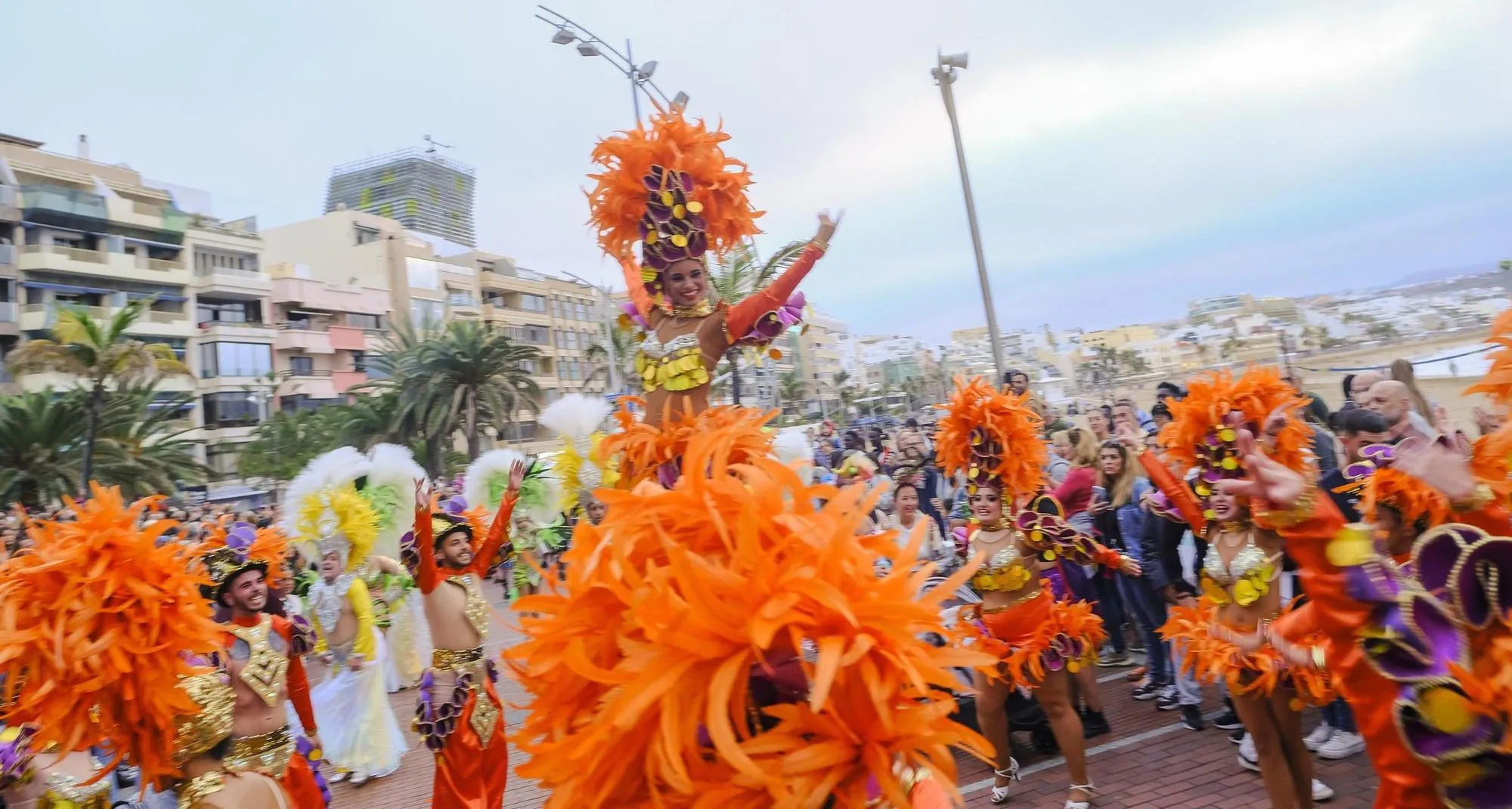 Comparsa de batucada con plumas coloridas desfilando en el Carnaval de Las Palmas