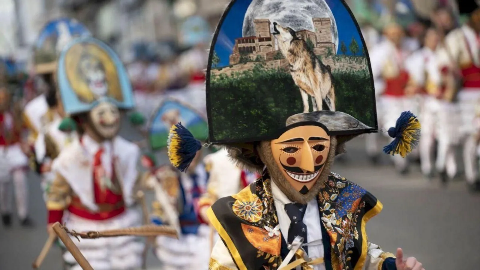 Peliqueiros con máscaras de madera tallada y sombreros pintados en el Entroido de Ourense